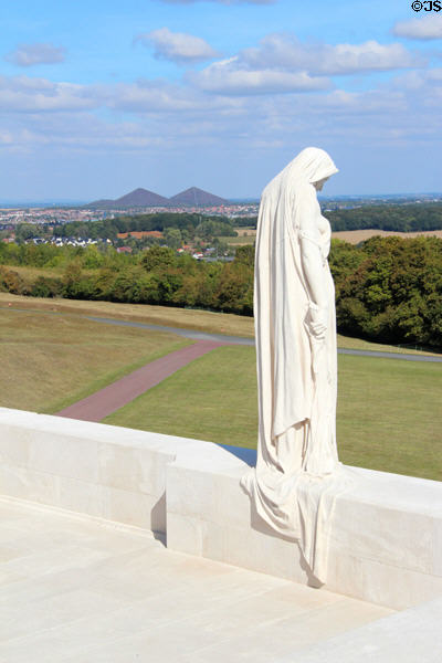 Cloaked figure of Canada stands on heights of German -defended ridge mourning over Douai Plain from which Canadians attacked uphill at Vimy Ridge Memorial. Vimy, France.