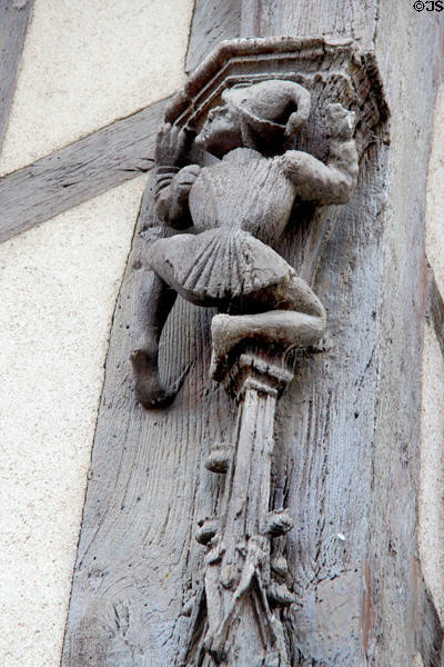 Carving detail of man in Medieval dress climbing pillar on Acrobats house. Blois, France.