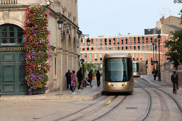 Tram passes flowers on Place St Croix. France.