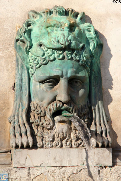 Fountain bronze face with lion headdress (19thC) by Antoine Laurent Dantan on Arles Obelisk pedestal. Arles, France.