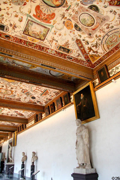 East corridor with painted ceilings & historical figures at Uffizi Gallery. Florence, Italy.
