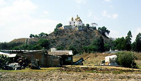 Church sitting on top of an earth mound which conceals largest pyramid in world, Cholula. Mexico.