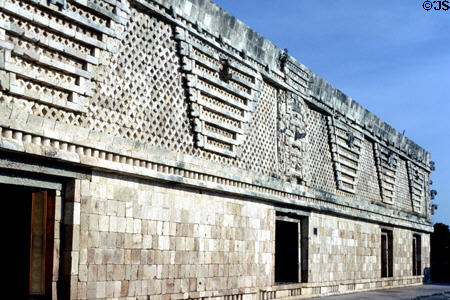 Frieze with reliefs of Maya huts against a background of lattice ornament adorns top of a Nunnery Quadrant building at Uxmal. Mexico.