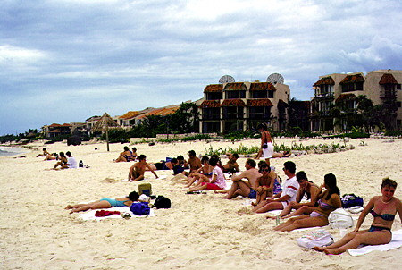 Tourists sunbathe on beach in Cancún. Mexico.