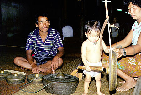 Baby with gong in Ugat longhouse, Sarawak. Malaysia.
