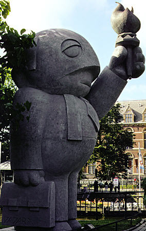 Statue of humorous businessman with briefcase & torch on bridge in front of Rijksmuseum. Amsterdam, Netherlands.