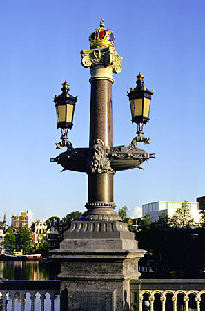 Ornate street lamps on Blauwbrung bridge near opera. Amsterdam, Netherlands.