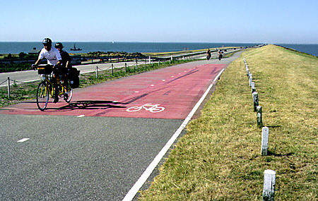 Bicyclists riding along the 30 km dike in Afsliuitdijk. Netherlands.