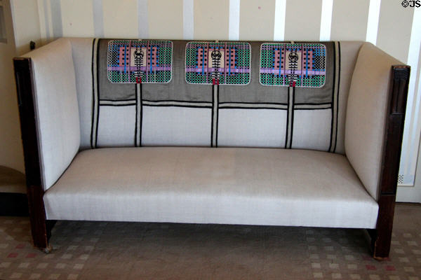 Upholstered settle (1904) by C.R. Mackintosh with replicas of antimacassars embroidered by Margaret Mackintosh in drawing room at Hill House. Helensburgh, Scotland.
