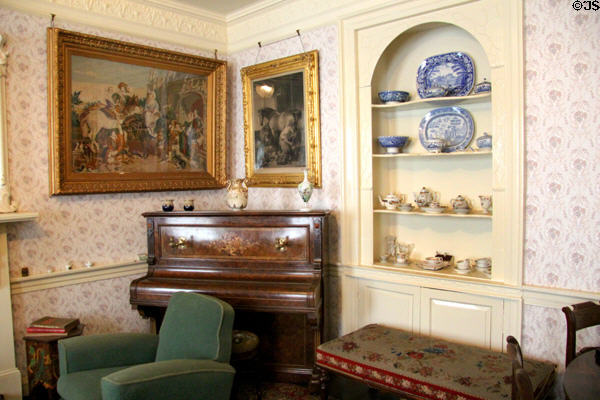Corner of drawing room with embroidery, piano & buffet with china in Reid farmhouse at National Museum of Rural Life. Kittochside, Scotland.