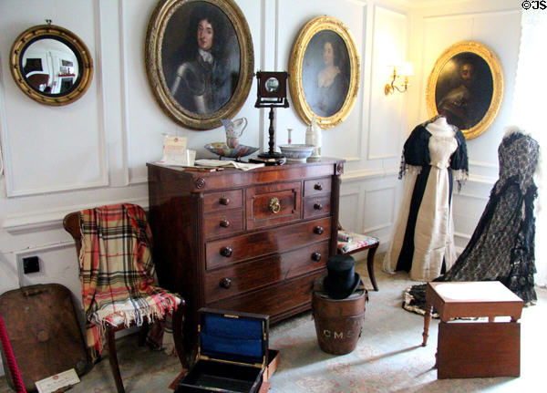 Dressing room with portraits & Scottish chest of drawers with square drawer for hats at Traquair House. Scotland.