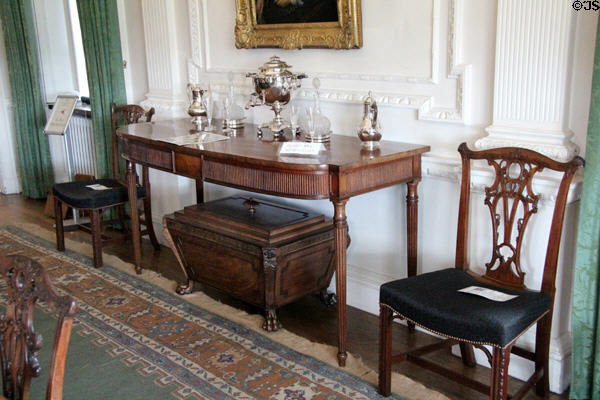 Side table with silver serving pieces over Regency wine cellerette in Egyptian style plus Chippendale style chairs at Hill of Tarvit Mansion. Cupar, Scotland.