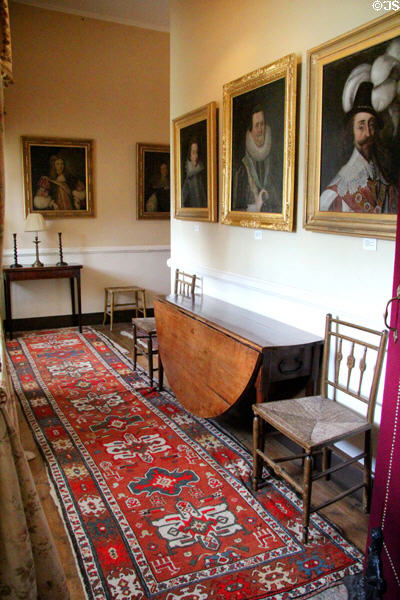 Hallway with runner carpet, drop-leaf table & Fraser portraits at Castle Fraser. Aberdeenshire, Scotland.