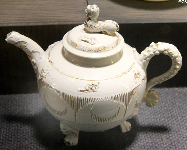 White teapot with applied molded leaf sprays relief decoration plus gilding (1730-60) made in North Straffordshire at Potteries Museum & Art Gallery. Hanley, Stoke-on-Trent, England.