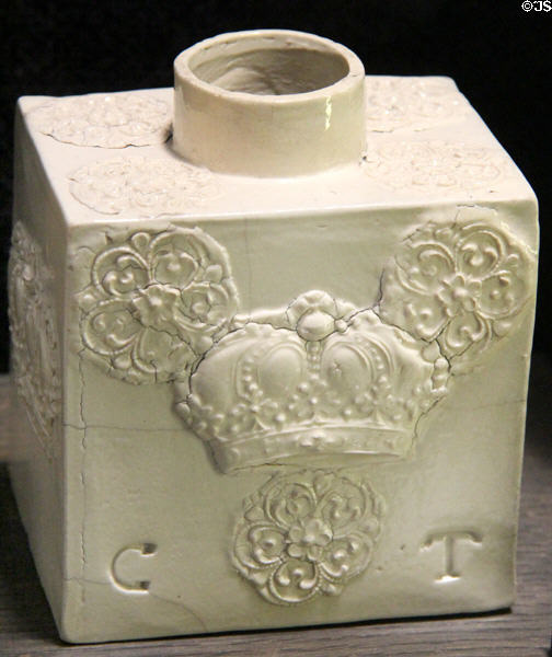 White tea canister of joined flat slabs with applied molded crown relief decoration & incised initials CT (1740-60) made in North Straffordshire at Potteries Museum & Art Gallery. Hanley, Stoke-on-Trent, England.