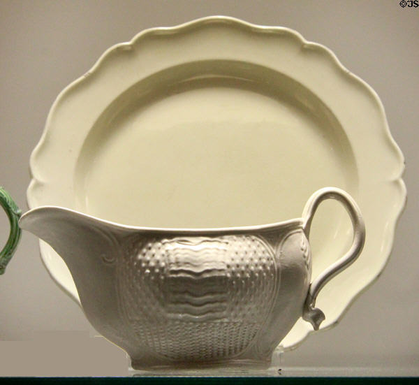 Creamware plate with scalloped rim (1760-1800) & salt-glazed stoneware sauce boat in 'seed & basket' pattern (1740-50) both from Staffordshire at Potteries Museum & Art Gallery. Hanley, Stoke-on-Trent, England.