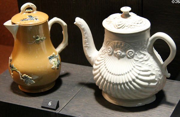 Ochre stained covered jug with applied molded relief decoration (1755-65) & salt-glazed stoneware teapot in shell pattern (c1750-60) both from Staffordshire at Potteries Museum & Art Gallery. Hanley, Stoke-on-Trent, England.