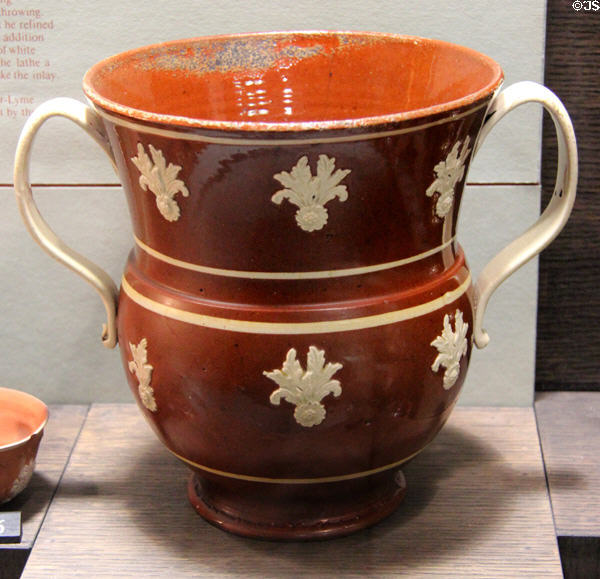 Red earthenware loving cup with applied molded relief decoration (c1740-60) made in Straffordshire at Potteries Museum & Art Gallery. Hanley, Stoke-on-Trent, England.
