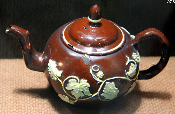 Red earthenware teapot with applied molded relief decoration (c1740-60) made in Straffordshire at Potteries Museum & Art Gallery. Hanley, Stoke-on-Trent, England.