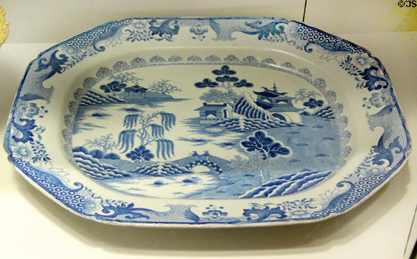 Ironstone china meat dish transfer-printed with chinoiserie willow pattern (c1815) by C.J. & G.M. Mason of Lane Delph, Fenton, Stoke-upon-Trent at Potteries Museum & Art Gallery. Hanley, Stoke-on-Trent, England.