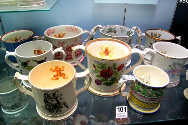 Collection of frog mugs used as jokes to startle 19thC beer drinkers when they saw toads considered poisonous emerge from their dark brews at Potteries Museum & Art Gallery. Hanley, Stoke-on-Trent, England.