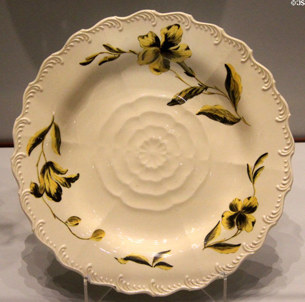 Queen's Ware plate with molded Tudor rose & painted yellow & black enamel flower (c1769) prob. James Bakewell for Wedgwood at World of Wedgwood. Barlaston, Stoke, England.