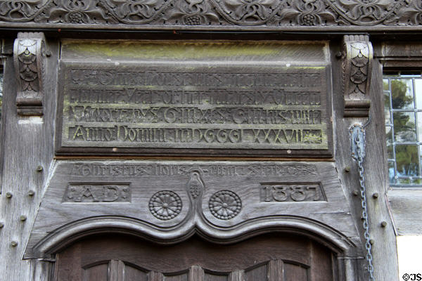 Carved wooden gothic text celebrating Queen Victoria (1887) over front door at Wightwick Manor. Wolverhampton, England.