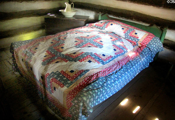 Bed with quilt in Log Cabin at Ulster American Folk Park. Omagh, Northern Ireland.
