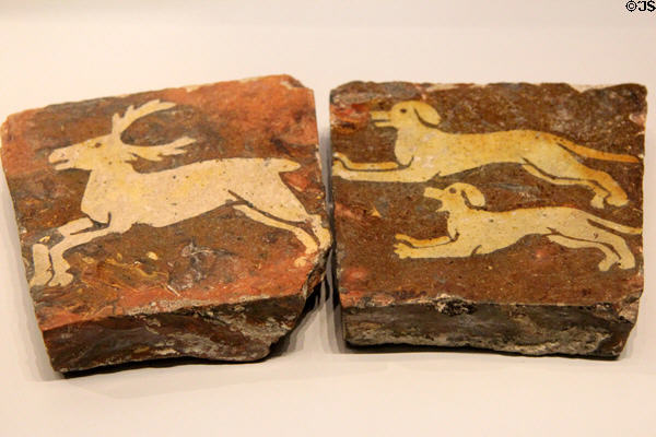 Dog chasing stag earthenware floor tiles (c1200-1300) from France at British Museum. London, United Kingdom.