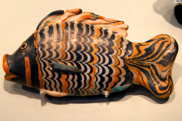 Polychrome glass cosmetic bottle in form of 'bulti'-fish (18th Dynasty - c1350 BCE) found under floor in house in el-Amarna, Egypt at British Museum. London, United Kingdom.