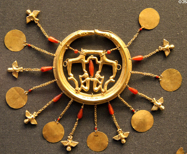 Minoan gold earring comprises snakes circling hounds & monkeys with pendant discs & owls at British Museum. London, United Kingdom.