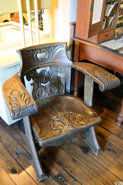 Ornate carved wooden armchair with curved back at Tuolumne County Museum. Sonora, CA.