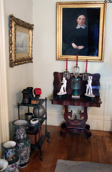 Parlor side table with luster candlestick & bric-a-brac under paintings at Pardee Home Museum. Oakland, CA.