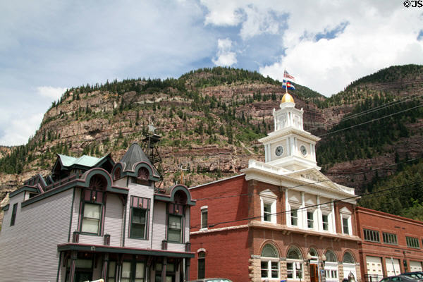Ouray City Hall & new Victorian home (1985) against mountains surrounding Ouray. Ouray, CO.