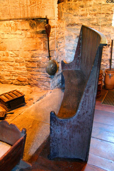 Pine settle (mid-18thC) curved for stability & designed to trap heat around sitters at Henry Whitfield State Museum. Guilford, CT.