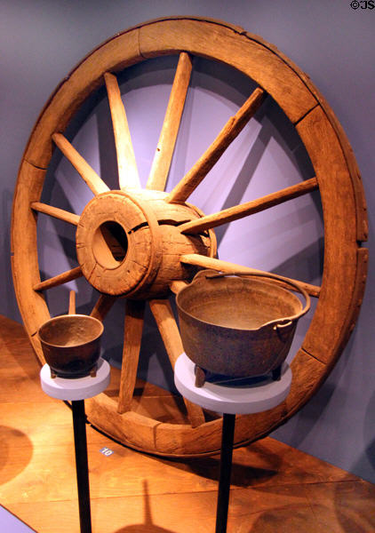 Revolutionary era wagon wheel (1775) used to carry military supplies to Yorktown, VA plus iron cooking pots (1700-1800s) at Connecticut Historical Society. Hartford, CT.