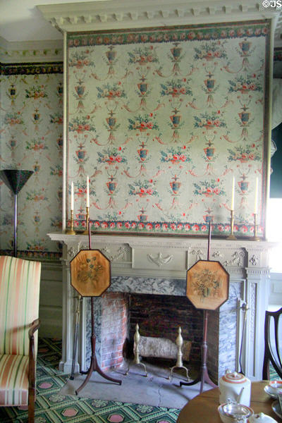 Parlor fireplace with Adamsesque carvings & reproduction wallpaper over firescreens at Phelps-Hathaway House. Suffield, CT.
