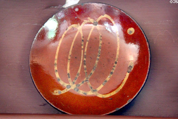 Redware plate with looped yellow slip decoration, a Connecticut style, at Silas Deane House. Wethersfield, CT.