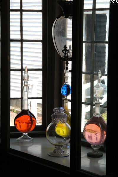 Flasks with colored liquids in window of Drug Store at Mystic Seaport. Mystic, CT.