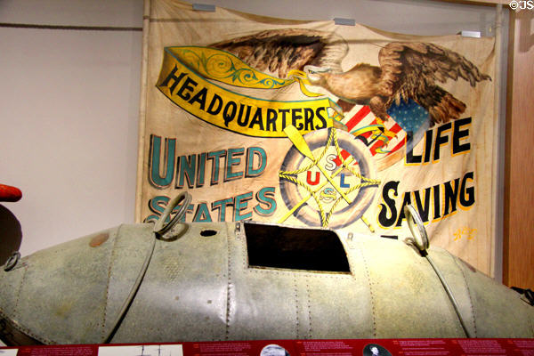 Life saving parade banner (c1910) & life-car (c1870) used for ship to shore rescues at U.S. Coast Guard Museum. New London, CT.