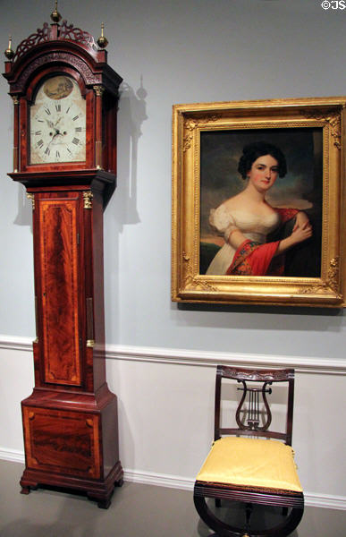 Tall clock (1753-1848) by Simon Willard of Roxbury, MA beside portrait of Julianna Hazlehurst (c1820) by Jacob Eichholtz & sidechair (1815-20) attrib. to Duncan Phyfe of New York at National Gallery of Art. Washington, DC.