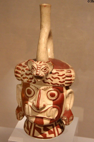 Moche ceramic stirrup-spout bottle figure of Wrinkle Face with fangs, snake ears & feline headdress (100-800) from Peru at Dumbarton Oaks Museum. Washington, DC.