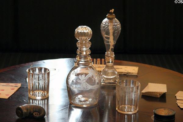 Glass tumblers (c1850) from Germany which belonged to Confederate President Jefferson Davis; glass gin decanter (1780-1820); & pressed glass whale oil lamp (c1840) n Kentucky period parlor (1830-40) at DAR Memorial Continental Hall. Washington, DC.