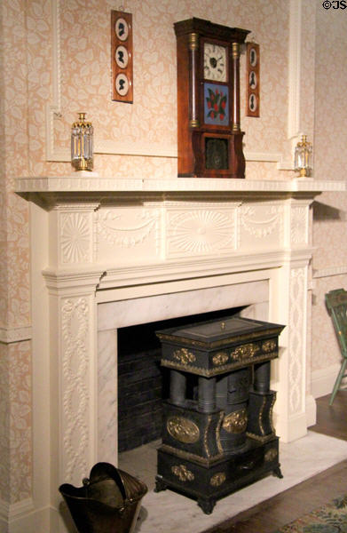 Fireplace with stove (mid 19thC) attrib. Isaac Orr of DC & mantle clock (1830-40) by Seth Thomas of CT in Illinois period bedroom at DAR Memorial Continental Hall. Washington, DC.