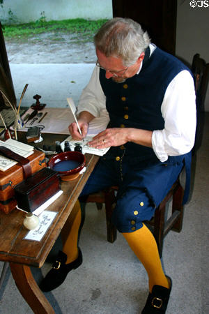 Scribe writes with quill pen at Colonial Spanish Quarter Museum. St Augustine, FL.