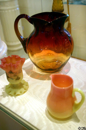 Late 19th C art glass (amberina pitcher plus Burmese glass vase & pitcher) at Lightner Museum. St Augustine, FL.