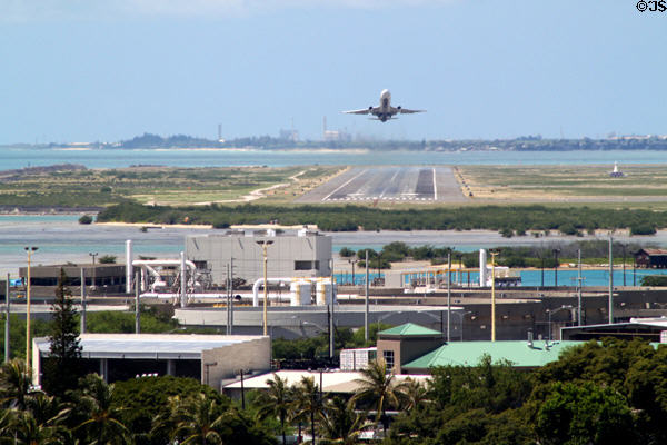 Plane takes off from reef runway of Honolulu International Airport. Honolulu, HI.