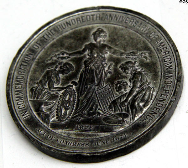 Liberty crowning industry & arts Medal (1876) from Centennial Exhibition in Philadelphia at Sandwich Glass Museum. Sandwich, MA.