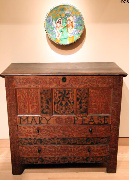 Chest of drawers (c1714) possibly by John Pease, Jr. of Endfield, CT under earthenware disk (c1690) from England at Museum of Fine Arts. Boston, MA.