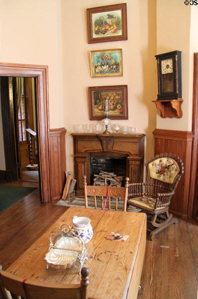 Sitting room with fireplace, mantle clock & stationary rocking chair at Vaile Mansion. Independence, MO.